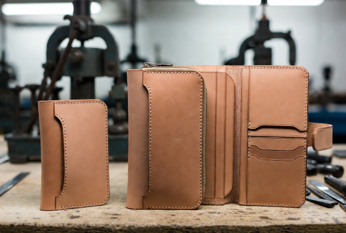 Side-by-side simple bifold, zip-around, and organizer leather wallets showing construction differences and impact on manufacturing cost